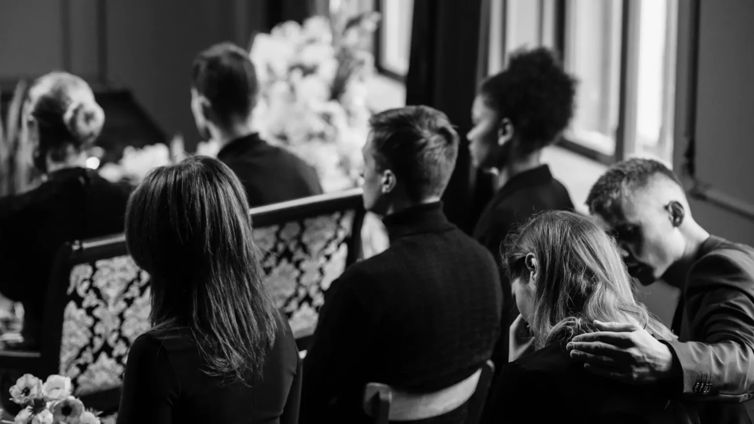 Un groupe de personne assiste aux obsèques d'une personne.