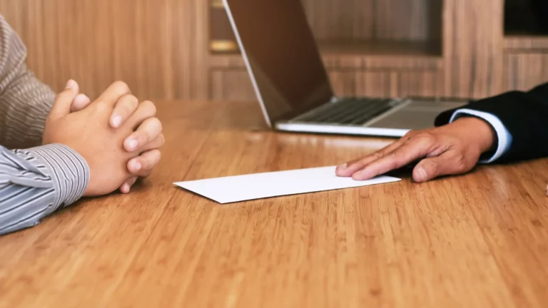 Deux hommes assis face à face dans un bureau, probablement un client qui viens résilier son contrat chez son courtier.